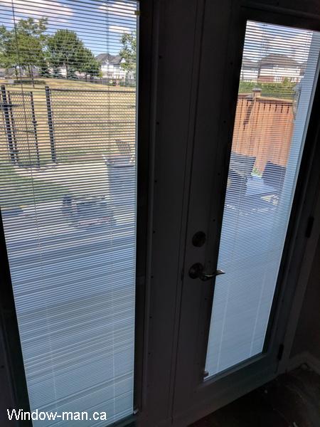 Patio French doors with blinds. Inswing. White. Tilt and lift internal Mini Blinds. The blinds are down. The pic 4015 view from inside